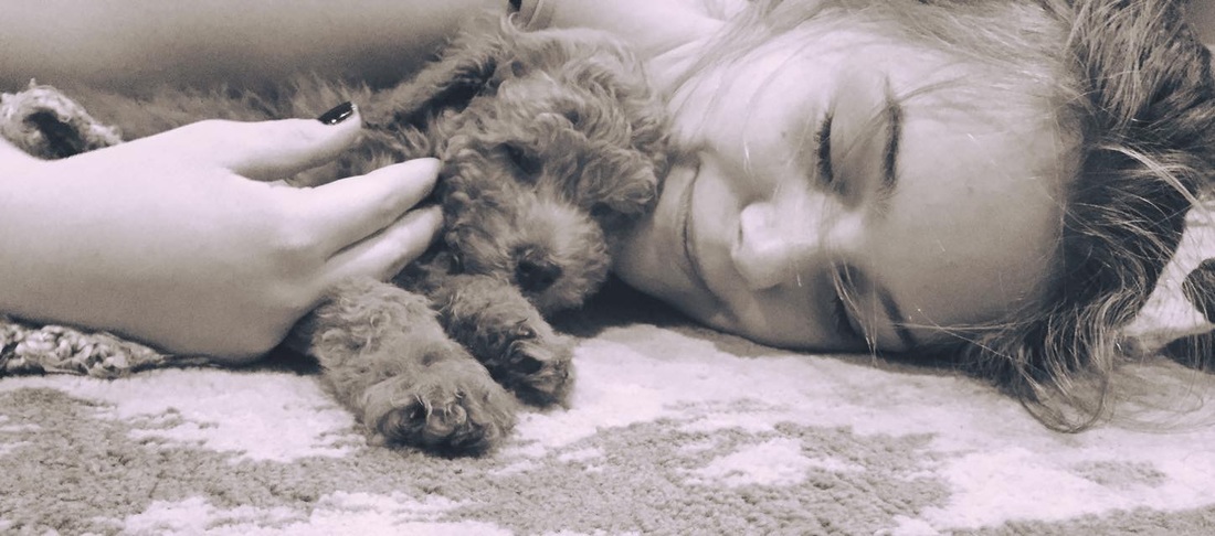 Picture of sleeping girl cuddling a Poodle